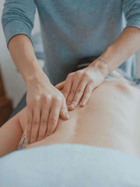 A person receiving a back massage from a massage therapist, experiencing the soothing techniques of various massage therapies.